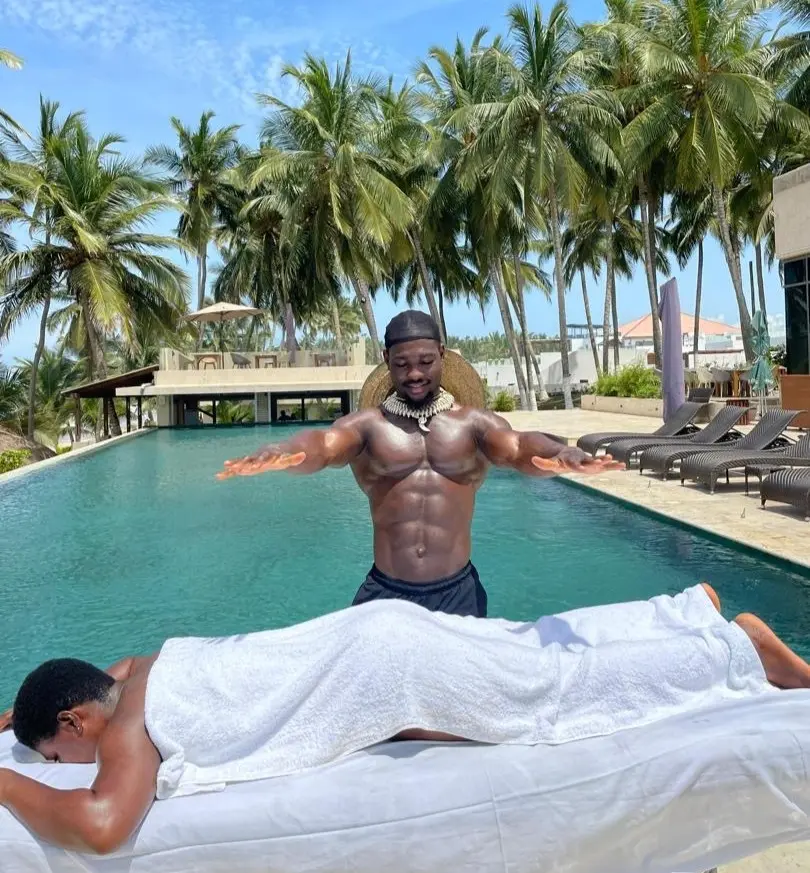 A poolside massage session in progress, with a therapist massaging a client's back while they float on a pool lounger