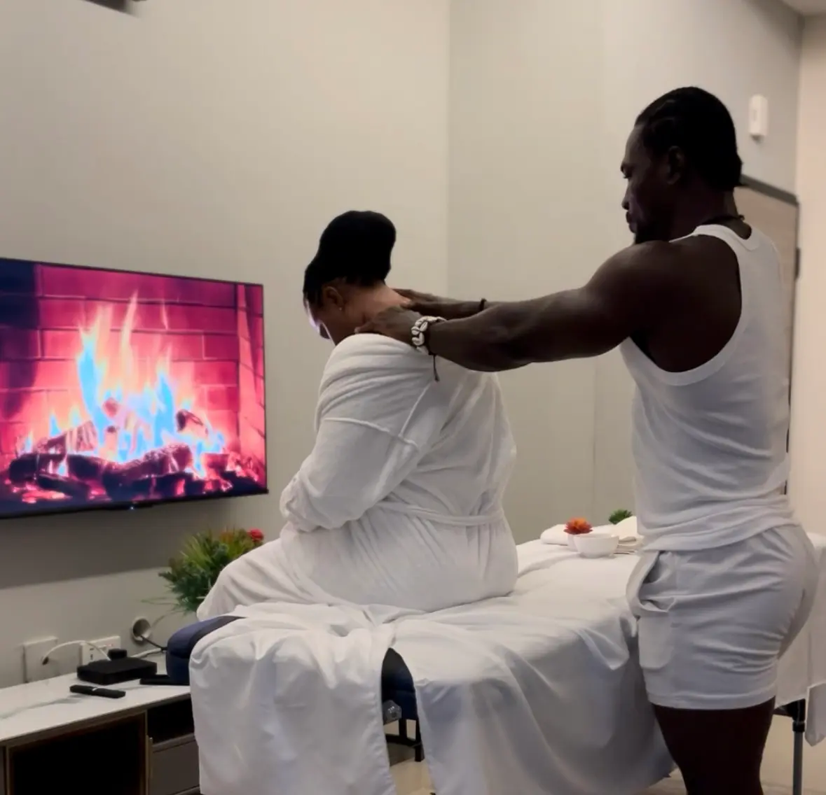 A spa therapist placing warm stones on a client's back in a tranquil setting
